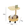 A two-tiered side table with wheels, displaying a cup, a calendar, and some books. Produktbild-Vorschau