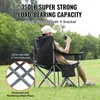 A man sits in a camping chair outdoors, holding a drink. Produktbild-Vorschau