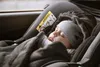 A baby sleeping in a car seat, covered with a blanket. Produktbild-Vorschau