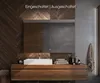 A modern bathroom vanity with a sink and mirror, featuring wooden cabinetry and a concrete wall. Produktbild-Vorschau