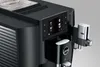 Close-up of a black superautomatic coffee machine with a silver milk frother attachment. Podgląd zdjęcia produktu