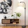 A modern living room scene featuring a floor lamp, a cabinet, and artwork. Anteprima dell’immagine prodotto