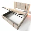 A beige upholstered bed frame with the mattress support slats lifted, revealing the storage space underneath. The headboard is also upholstered and features decorative vertical elements. Náhled obrázku produktu