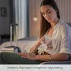 A woman is sitting and using a breast pump. Produktbild-Vorschau