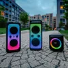 Three LAMAX speakers are placed on a cobblestone path in front of apartment buildings. Produktbild-Vorschau