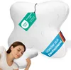 A woman is sleeping on a white pillow with a butterfly shape. The pillow has tags attached to it. Produktbild-Vorschau