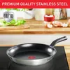 A frying pan is shown on a stovetop, with a kitchen counter and ingredients in the background. Produktbild-Vorschau