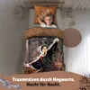 A young boy is sleeping in a bed with Harry Potter-themed bedding. The bedding features an illustration of Hogwarts castle and Harry Potter casting a spell. Produktbild-Vorschau