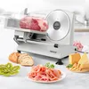 A slicer with a piece of meat on it, surrounded by sliced bread, kiwi, ham, and cheese. Produktbild-Vorschau