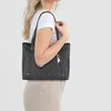 A woman is holding a tote bag. Produktbild-Vorschau