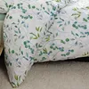 A close-up view of a white duvet cover with a green and blue floral pattern. Produktbild-Vorschau