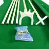 A close-up view of billiard cues, a bridge, and chalk on a green billiard table. Produktbild-Vorschau