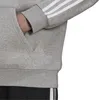 Close-up of a person's hand in the pocket of a grey Adidas hoodie with white stripes on the sleeve. Anteprima dell’immagine prodotto