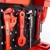 A close-up view of a toy workshop tool set, showing various red plastic tools hanging on a black pegboard. Náhled obrázku produktu