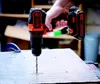 A hand holding a cordless drill and drilling into a surface. Anteprima dell’immagine prodotto