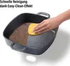A hand is cleaning a square pan with a sponge, showing the ease of cleaning. Anteprima dell’immagine prodotto