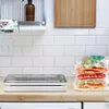 A kitchen counter with a vacuum sealer and stacked vacuum-sealed food items. Produktbild-Vorschau