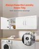 A white wall-mounted cabinet with two doors, one open, showing storage inside, above a countertop with a washing machine and laundry supplies. Podgląd zdjęcia produktu