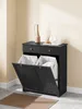 A black cabinet with two drawers and two laundry baskets, placed in a room with light beige walls and a gray floor. Podgląd zdjęcia produktu