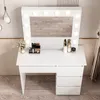 A white vanity table with a lighted mirror and makeup products on top, set against a light gray and wood-paneled wall. Podgląd zdjęcia produktu