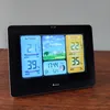 A digital weather station displaying outdoor and indoor temperature, humidity, forecast, time, and moon phase. Produktbild-Vorschau