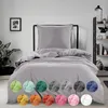A bed with gray bedding is shown in a room setting. Below the bed, there are circular swatches of different colored bedding options. Náhľad obrázku produktu