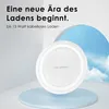 A white wireless charger is displayed on a light blue platform against a backdrop of a sky with clouds. Produktbild-Vorschau