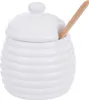 A white ceramic honey pot with a lid and a wooden dipper. Náhled obrázku produktu