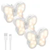 Three butterfly-shaped LED night lights and two USB charging cables are displayed against a white background. Produktbild-Vorschau