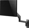 A black monitor arm mounted on a white wall, holding a black monitor. Podgląd zdjęcia produktu