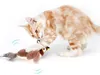 Braun-weißes Plüschvogel-Katzenspielzeug mit Federn, mit dem eine orange getigerte Katze spielt Náhľad obrázku produktu