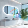 A modern bathroom vanity with a large oval mirror, sink, and faucet, featuring a tropical plant and a view of the ocean through a window. Podgląd zdjęcia produktu