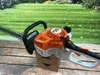 A Stihl hedge trimmer is placed on a wooden surface with a green grassy background. Produktbild-Vorschau