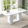A white oval dining table with storage cabinets at the base, set in a well-lit room with large windows overlooking a garden. Produktbild-Vorschau