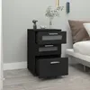 A black nightstand with three drawers is placed next to a bed in a bedroom. Produktbild-Vorschau