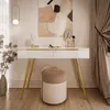 A modern vanity table setup with a white high-gloss console, gold legs, a quilted stool, and decorative items. Produktbild-Vorschau