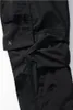 A close-up view of black cargo pants, showing pocket details and fabric texture. Produktbild-Vorschau