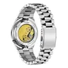 The back of a silver metal watch with a visible mechanical movement. Voir les images du produit