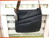 A dark blue Rieker handbag with a plaid heart charm hanging from the strap, displayed against a white and light gray slatted background. Produktbild-Vorschau