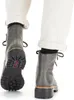 A close-up view of a person wearing gray lace-up boots and white pants, shown from the back and side. Produktbild-Vorschau