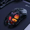 A futuristic-looking computer mouse with a skeletal design and internal lighting, placed on a dark mousepad. Náhled obrázku produktu