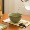 A matcha tea set is being prepared on a wooden table. Produktbild-Vorschau