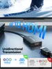 A black AV to HDMI adapter is shown connected to a black gaming console, with a large screen displaying a skier in the background. The text 'AV TO HDMI' is prominently displayed. Produktbild-Vorschau