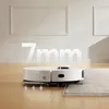 A white robot vacuum cleaner is shown on a wooden floor transitioning to a rug. The number "7mm" is superimposed on the image. Produktbild-Vorschau