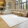 A large sectional sofa and a white rug in a well-lit living room with large windows. Produktbild-Vorschau