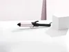 A pink and black curling iron is displayed on a white surface with a white cube in the background. Anteprima dell’immagine prodotto