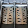 A close-up view of two stainless steel heat deflectors and burner tubes inside a grill. Anteprima dell’immagine prodotto