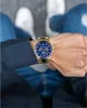 A person wearing a gold and blue Maserati watch on their wrist. Produktbild-Vorschau