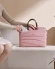 A person is placing a slim card into a pink laptop bag while sitting on a couch. Produktbild-Vorschau