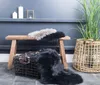 A wooden bench with two sheepskin rugs, a basket, and a plant in a woven basket. Voir les images du produit